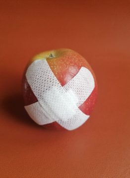 Erste Hilfe, ein Pflaster auf einem Apfel