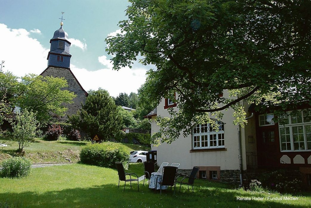 Bilden ein Ensemble: Die Laurentiuskirche und das Pfarrhaus in Arnoldshain.